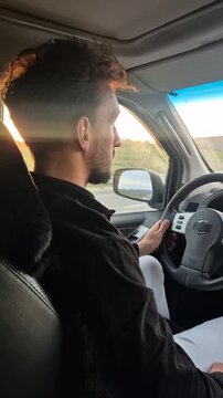 Driving man road trip handsome driver navigating highway at sunset in an automobile interior view
