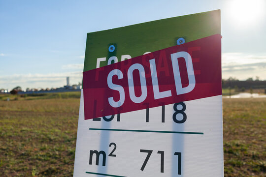 Sold sign on empty lot in new housing development area on the edge of town