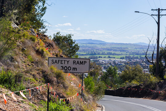 safety ramp 300m sign beside road on steep descent