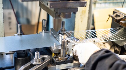 Metal stamping machine setup showing sheet metal positioning and press tooling