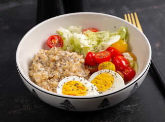 Healthy breakfast. Bowl of oatmeal and fresh vegetables and boiled egg.