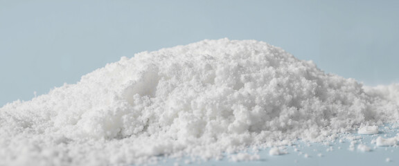 Pile of artificial white snow on a blue background showcasing texture and detail.