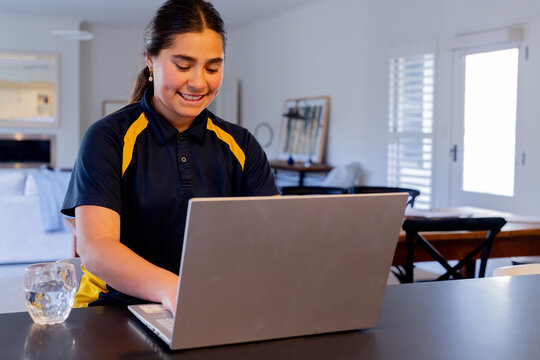 Tween girl doing homework using a laptop