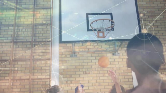 Team practicing under hoop, shooter releasing ball, coach catching while overlay guiding education