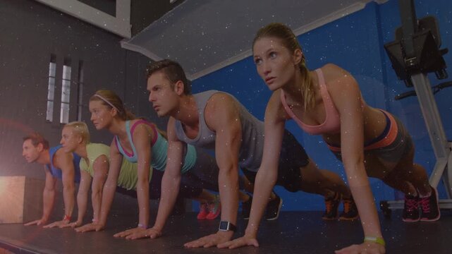 Five trainees answering coach cue, holding high plank on mat, staying aligned for fitness training