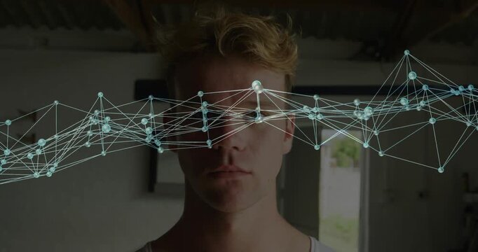 Man holding still nodes lines network appearing over eyes and sweeping across face, showing tech