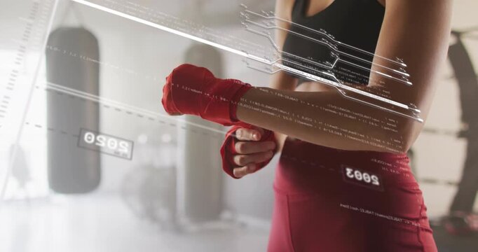 Female athlete threading red hand wrap, preparing for boxing while HUD scanning over hands and bags