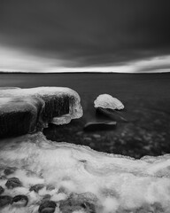Ice forms along the shoreline of lake Femunden in Norway during the winter season at twilight