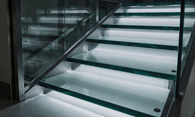 Obraz premium Glass Stair Treads - A modern staircase with treads made of thick, tempered glass, revealing the space below. A daring