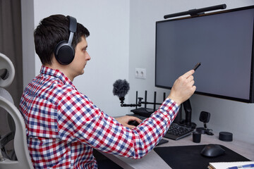 Man pointing stylus at computer screen, working from home