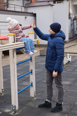 Father and daughter bonding, giving a high five, and playing outdoors during winter