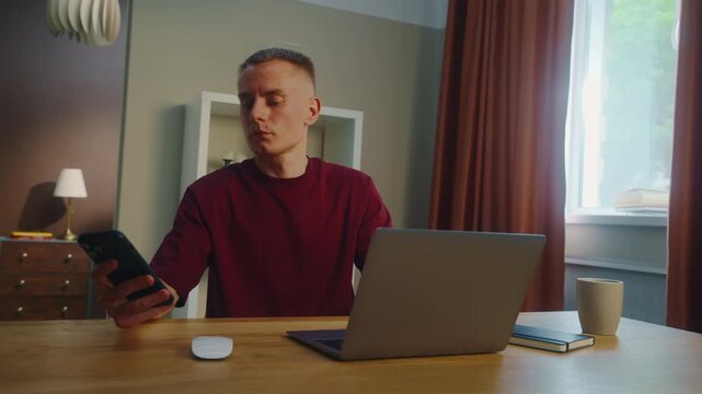 Distracted man worker remote work laptop home. Guy receive cool spicy sms mobile cell phone chatting. Male employee texting message. Ceo person take break rest. Online computer freelance distant job.