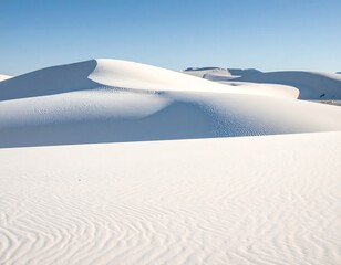 Expansive desert scene featuring rippling white dunes under a clear blue sky