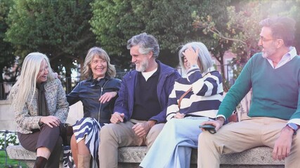 Group of senior friends laughing together on a park bench - Powered by Adobe