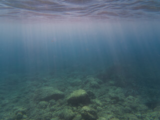 Sunbeams Penetrating Clear Mediterranean Sea Water to Illuminate a Rocky and Coral Seabed Underwater View with Light Rays.