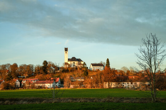 Parish church of St. John the Baptist in Bergkirchen, a municipality in the Upper Bavarian district of Dachau. Traditional rural village church on a hill at sunset.