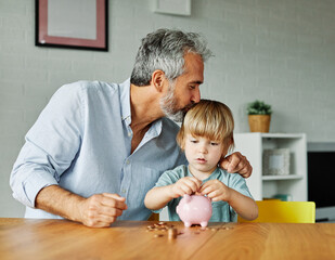 Fototapeta premium Grandparent And His Grandson Putting Coin Money In Piggybank At Home. Personal Savings, Bank Safety And Financial Investments Concept
