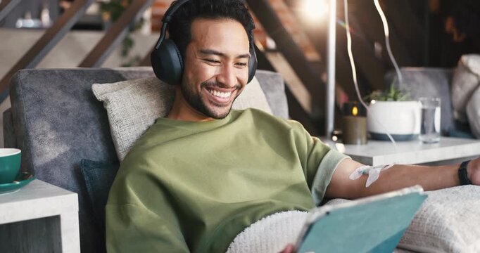 Happy man, tablet and drip therapy in lounge, relax or headphones with saline solution for immune system. Person, tech and iv for wellness benefits, vitamin or mineral infusion with app for streaming