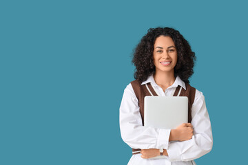 Obraz premium Young African-American businesswoman with laptop on blue background