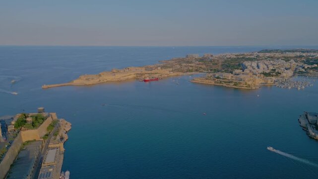 Aerial 4K panning shot of Fort St Angelo and the Grand Harbour in Birgu at sunset, Malta