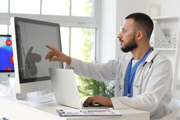 Male doctor analyzing scientific data at desk in laboratory