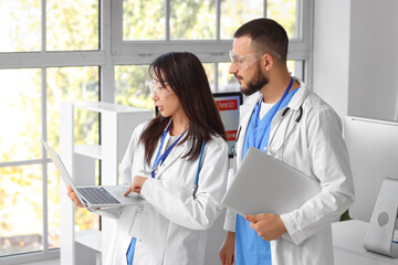 Doctors with laptops analyzing scientific data in laboratory