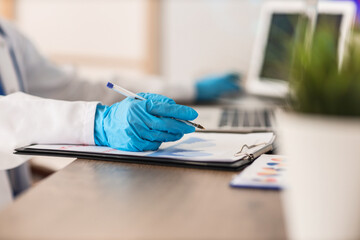 Female doctor analyzing scientific data at desk in laboratory, closeup