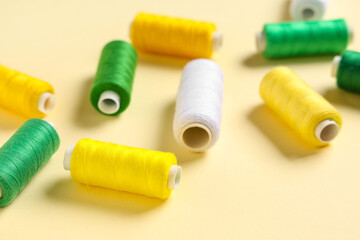 Colorful thread spools on beige background