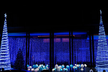 Christmas and New Year interior decoration with background, pine tree decorated with beautiful garlands of lights.