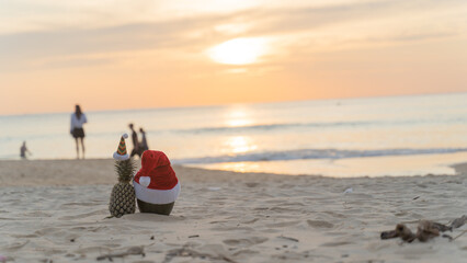 Santa Claus pineapple and watermelon couple wearing stylish sunglasses on the sand contrasting with the sea. wearing a christmas hat Christmas and New Year holiday ideas on the beach, Patong, Phuket