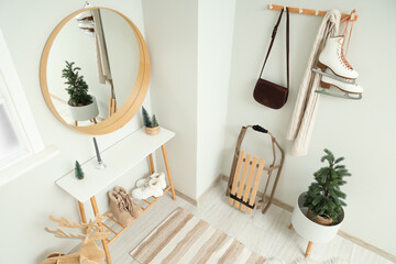 Interior of hallway with mirror, Christmas tree and sled