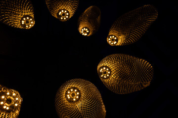 Abstract Golden Woven Pendant Lights Glowing in the Dark