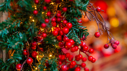 Christmas berries and evergreen branches with warm festive holiday lights