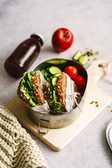 Gesunde Pausenbrote mit Salat, Gurke und Cocktailtomaten in einer Blech Box. To go. 