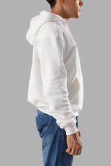 Young man in white hoodie on light background