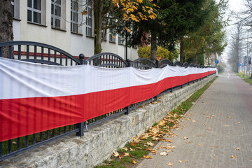 Materiał w barwach narodowych Polski rozciągnięty na płocie 