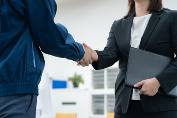 オフィスで握手をする作業服のエンジニア