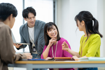 オフィスで会議をする男女のエンジニア