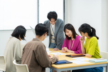 オフィスで会議をする男女のエンジニア
