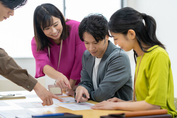 オフィスで会議をする男女のエンジニア
