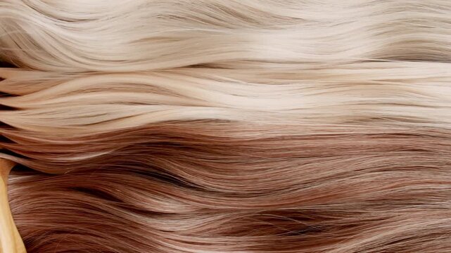 Light hair design, movement of a woman's hand, combing long curly light blonde hair. Hair restoration or care and barbershop or hairdressing concept. Beauty and glamour. Healthy shiny hairs. 4k