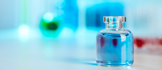 Small glass bottle filled with blue liquid in a bright science laboratory setting