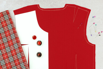 Women's clothing design. Sewing clothes from red fabric. Sewing patterns and accessories.