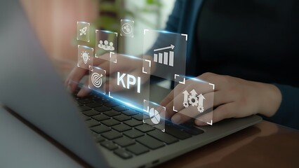 A person meticulously reviews key performance indicators (KPIs) on a laptop, with digital representations overlaying. This image captures the essence of data analysis and business monitoring.