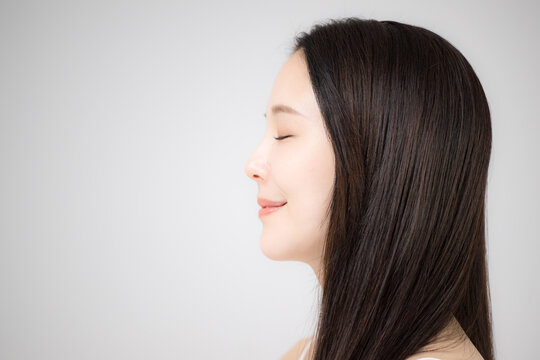 美容ポートレート、ストレートのロングヘアの髪の毛の手入れをする美しい髪の女性　目を閉じる横顔