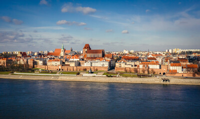 Fototapeta premium Drone view of historic part of Torun city over Vistula River in Poland with St John the Baptist Cathedral and Church of Holy Spirit