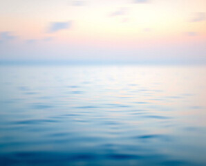 Obraz premium Title: A blurred of a calm ocean with soft pink and blue hues during sunset