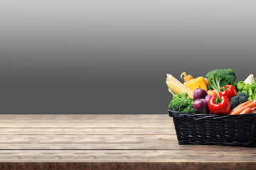 Fresh vegetables arranged in a basket on a wooden table, with a softly blurred background creating a warm and inviting atmosphere