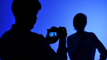 Backstage Silhouette of Photographer Shooting Model in Blue Light