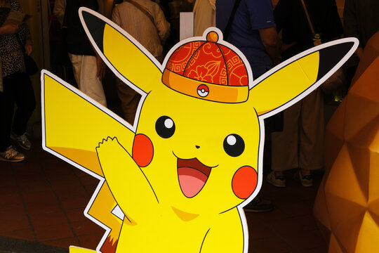 Singapore, Singapore - November 04, 2025: Pikachu stand with a festive hat welcomes visitors at store entrance, showcasing vibrant colors and playful design in a lively shopping environment